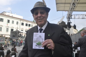 Il Presidente Onorario degli Alpini di Bergamo durante la loro sfilata con la cartolina fatta per l'occasione dall'ANMIG del Friuli Venezia Giulia - grafica Stefania Gallina